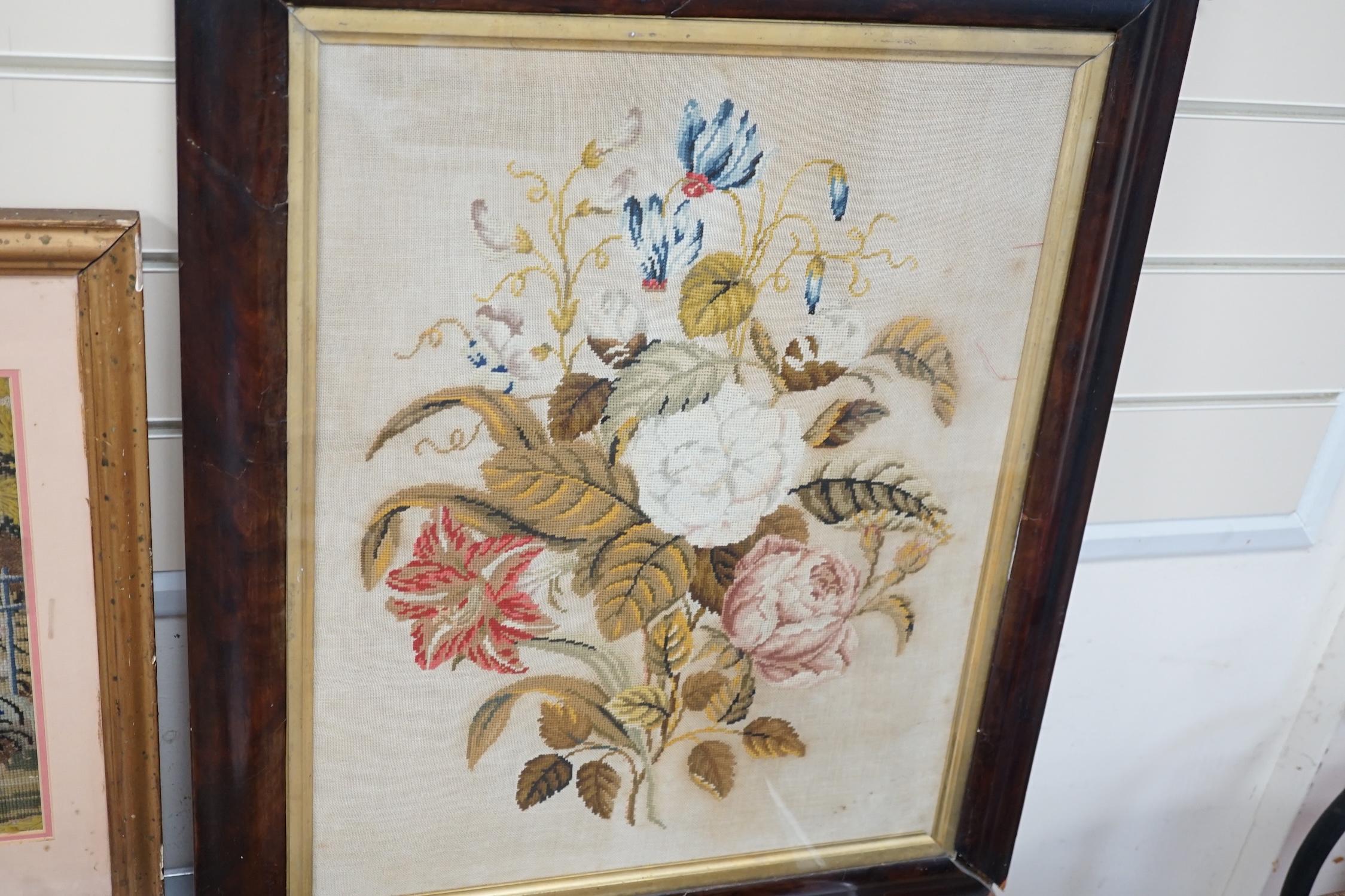 19th century and later framed embroideries (5); a 19th century wool worked still life embroidery, a later similar silk embroidery, a figurative wool worked embroidery, silk embroidery of a galleon and a landscaped wool w